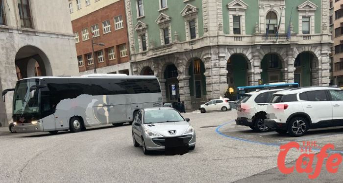 Auto ferma in mezzo alla strada a piazza Oberdan, curiosità tra i passanti