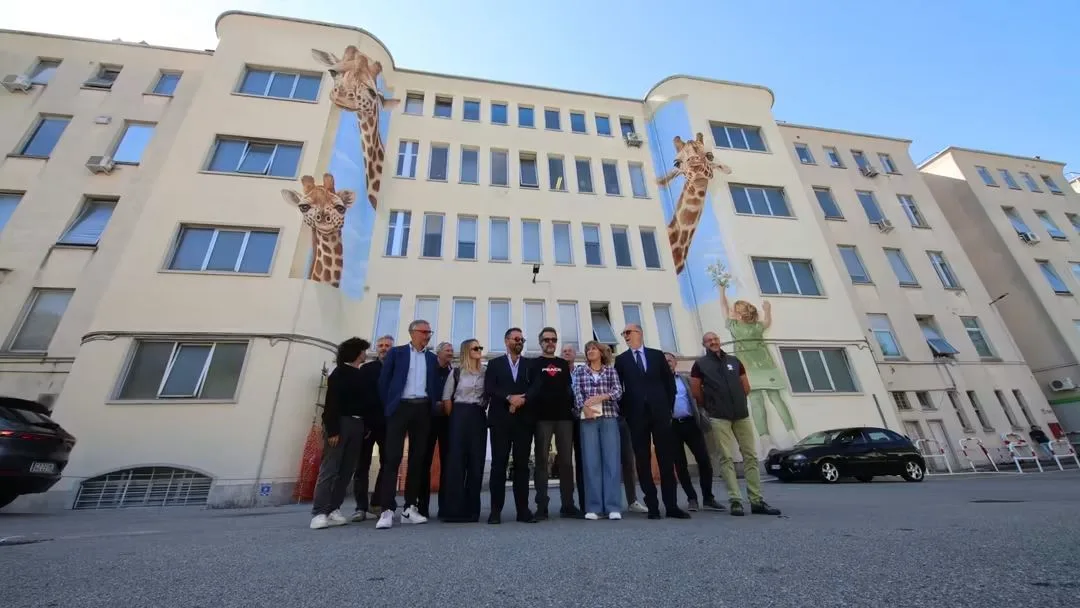 Due giraffe giganti accolgono bambini e famiglie al Burlo: la facciata si trasforma in un’opera d’arte