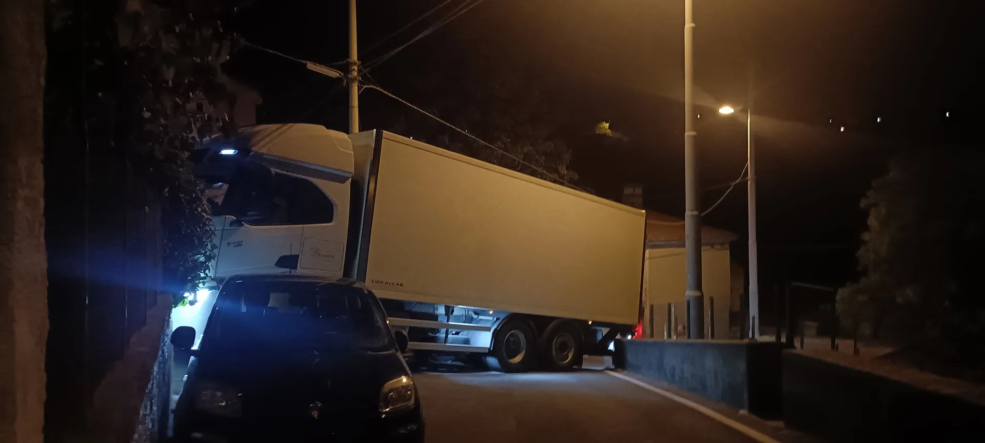 Camion incastrato nella notte in strada per Longera: muro danneggiato e polemica sui tempi di intervento